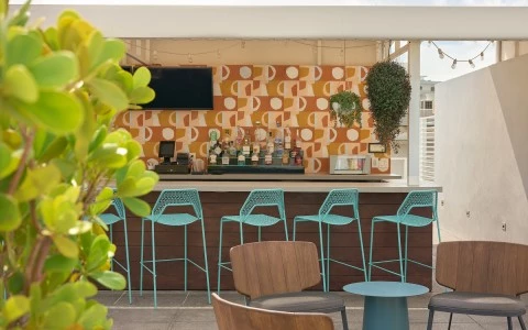 a bar with blue chairs and a wallpaper