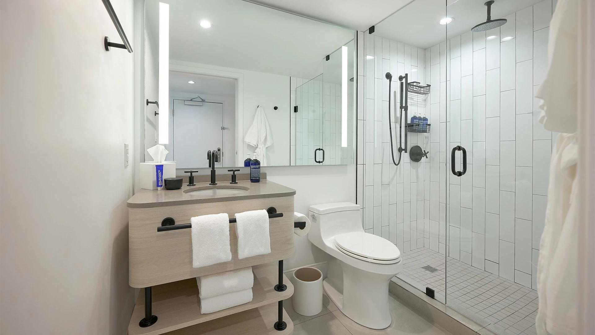A modern bathroom with a glass-enclosed shower, a floating sink, and a toilet.