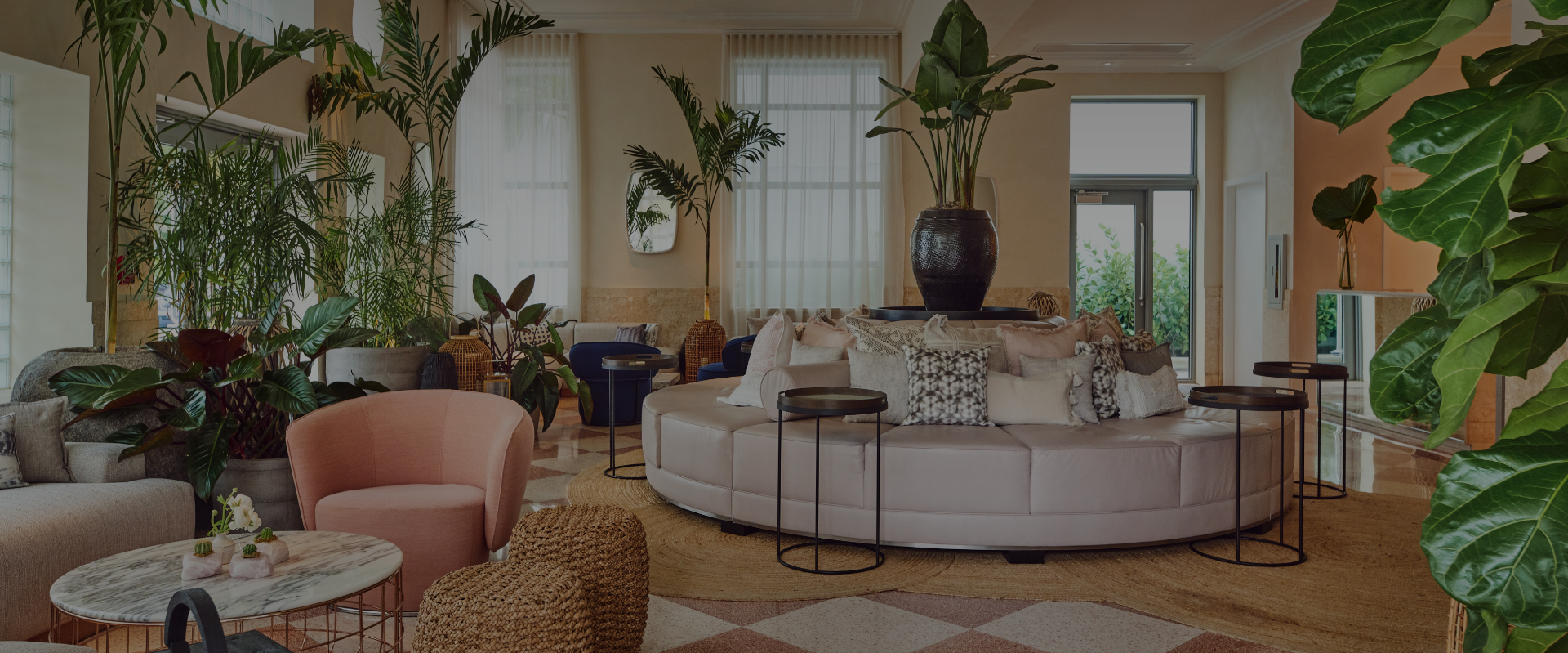 a room with a round couch and plants