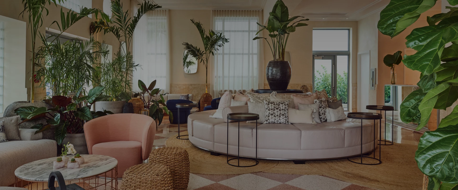 a room with a round couch and plants