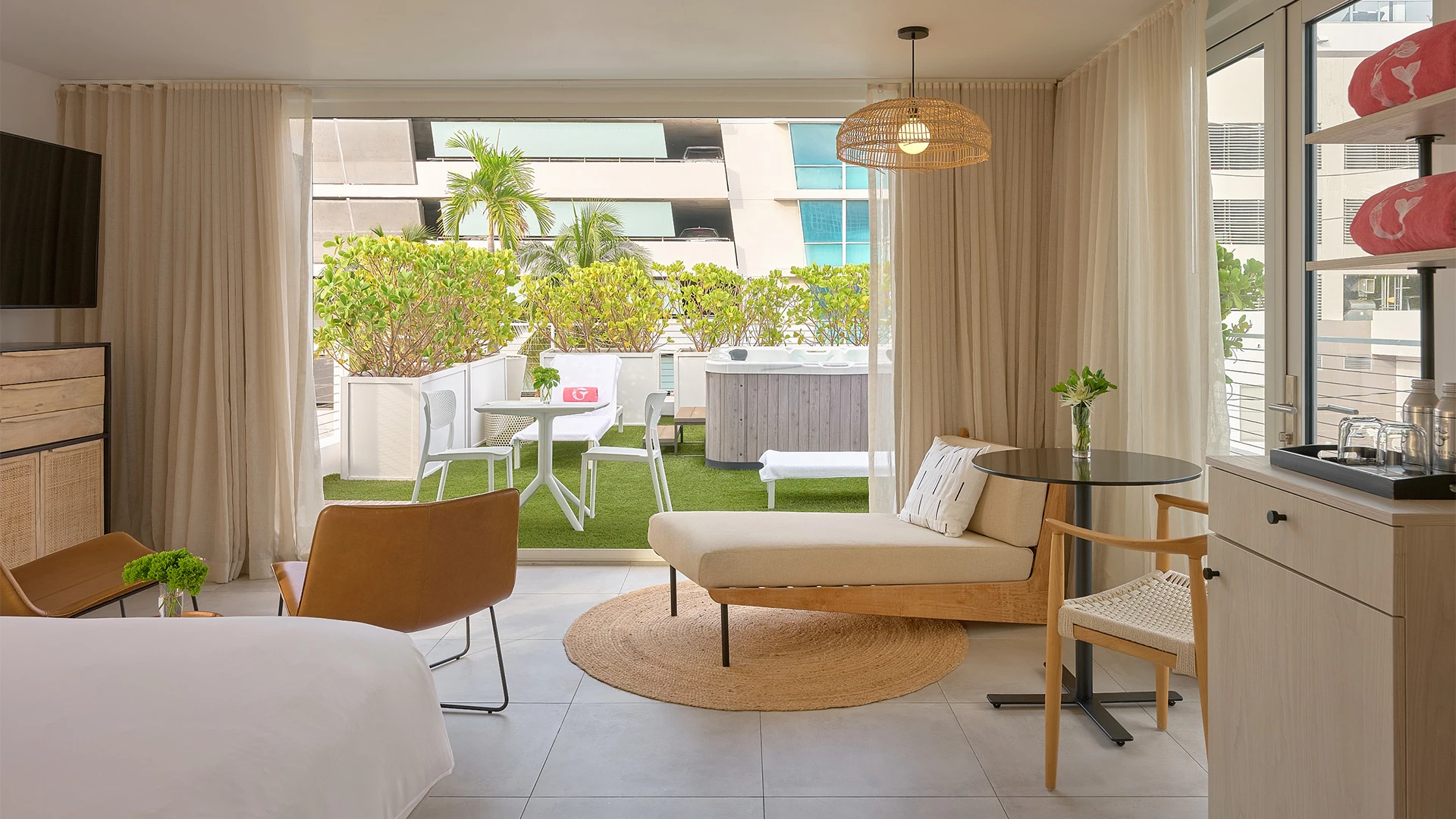 A suite with a bed, outdoor area, kitchenette, and TV