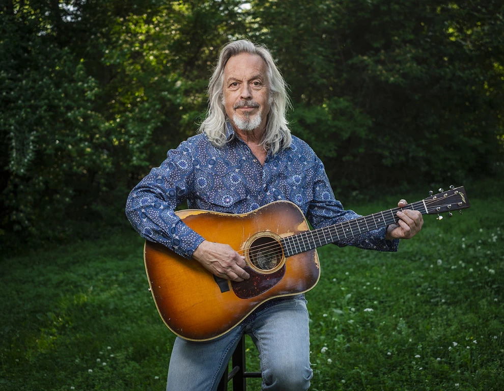 a man with long hair and a guitar