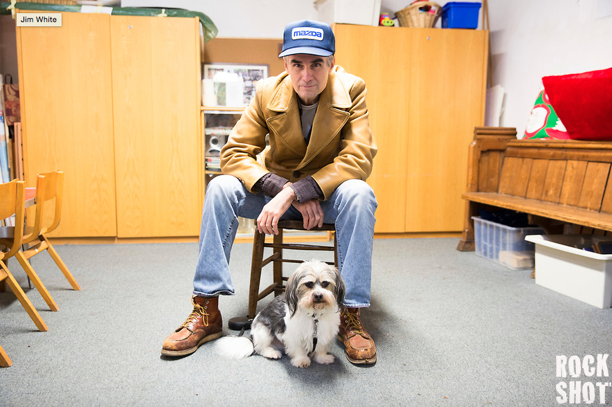 a man sitting on a stool with a dog