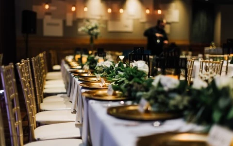 long banquet table set for wedding reception with place settings and center pieces