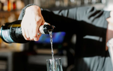 a person pouring a glass of champagne 