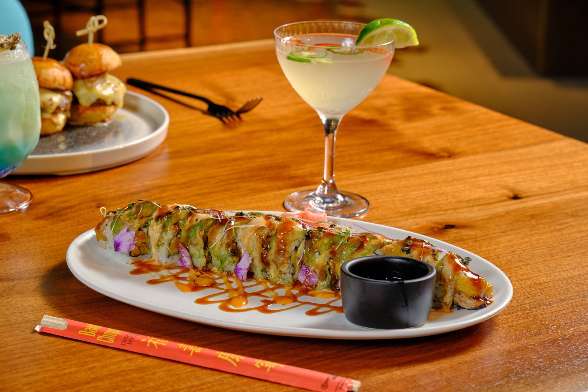 a plate of sushi and a drink on a table