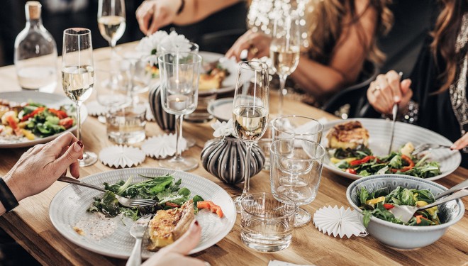 a table with plates of food and glasses of wine