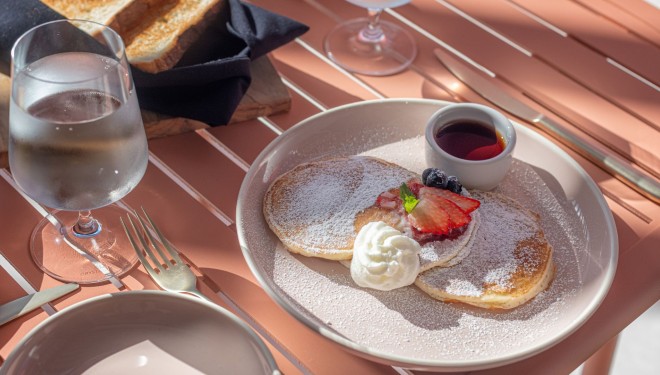 a plate of pancakes with syrup and fruit on it