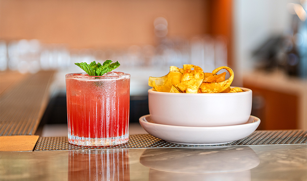 a bowl of chips and a drink