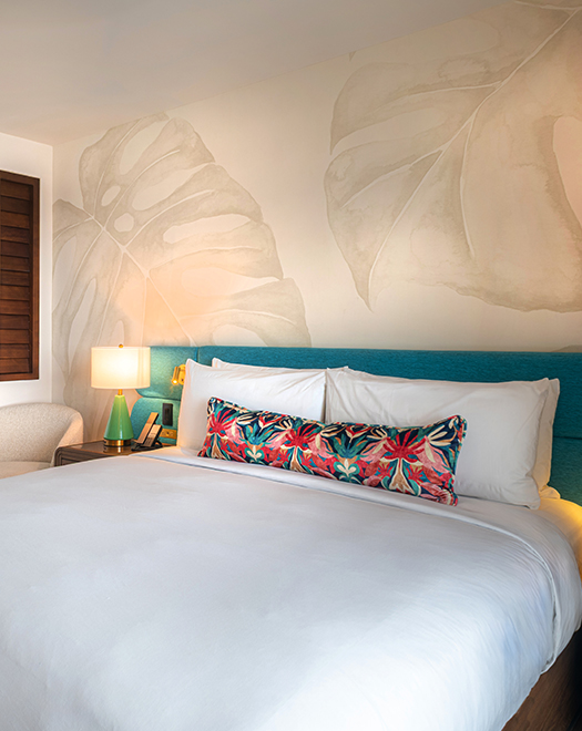 a bed with a blue headboard and a lamp