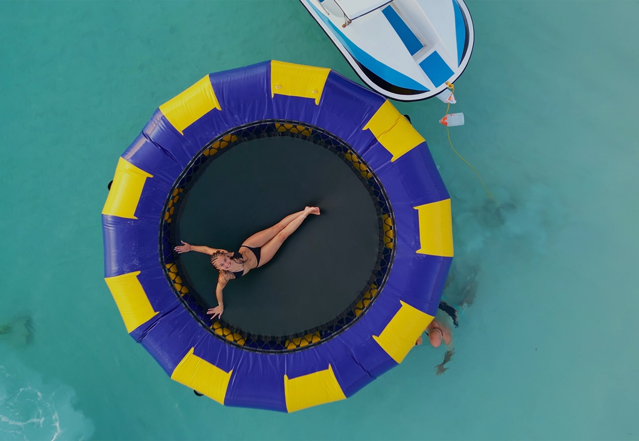 a woman lying on a trampoline in a body of water