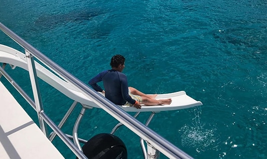 a man sitting on a white slide on a boat