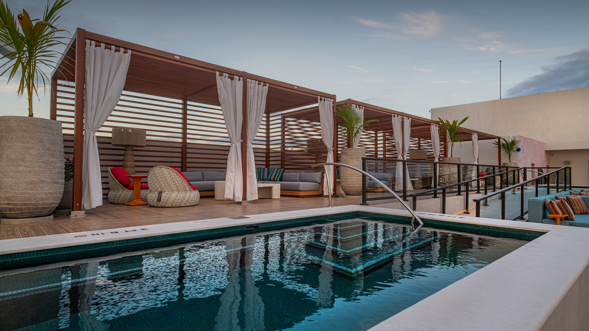 a pool with a hot tub and chairs