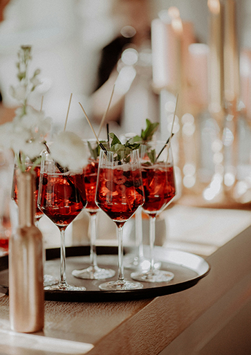 a group of wine glasses with red liquid on a tray