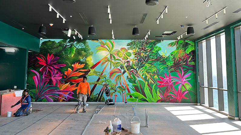 a man standing in front of a mural