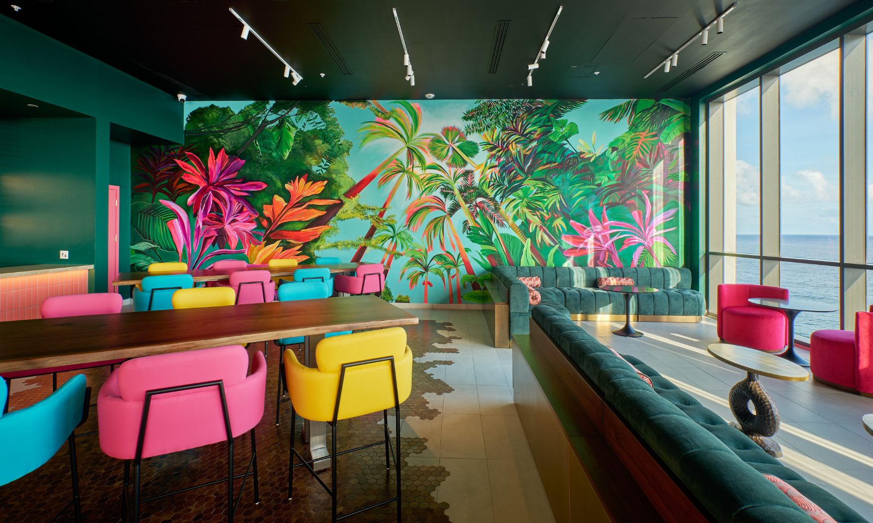 a colorful room with a large wall mural of palm trees