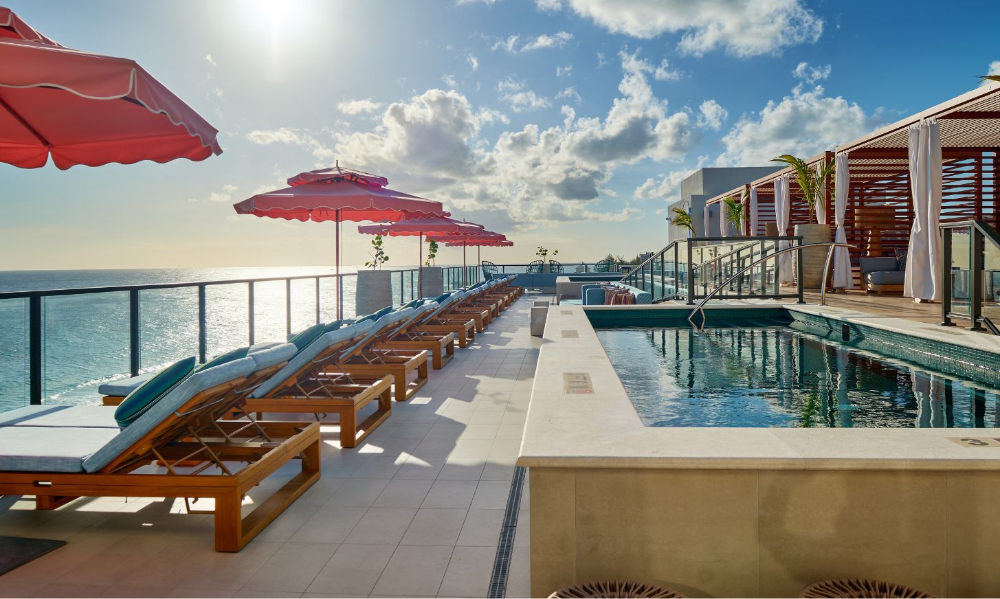 a pool with chairs and umbrellas on a deck
