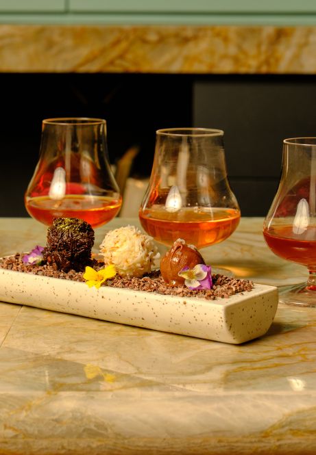 a group of glasses of alcohol and a rectangular object with chocolate balls