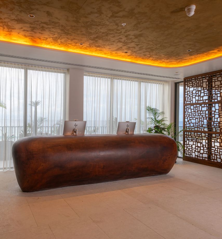 a desk in a room with a screen and windows