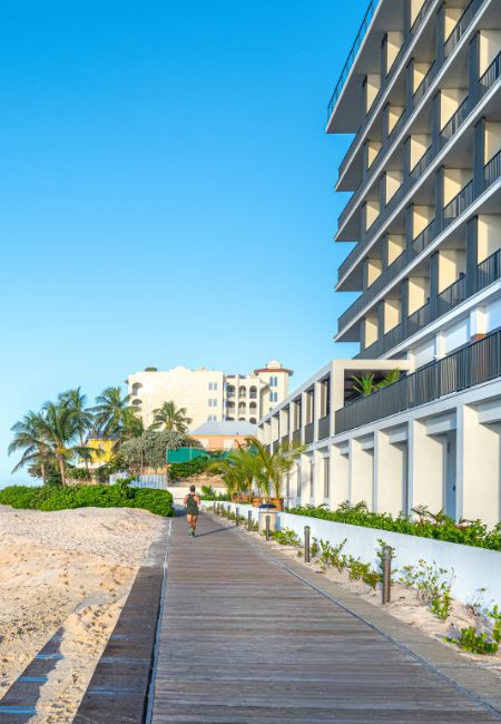 a person walking on a boardwalk next to a building