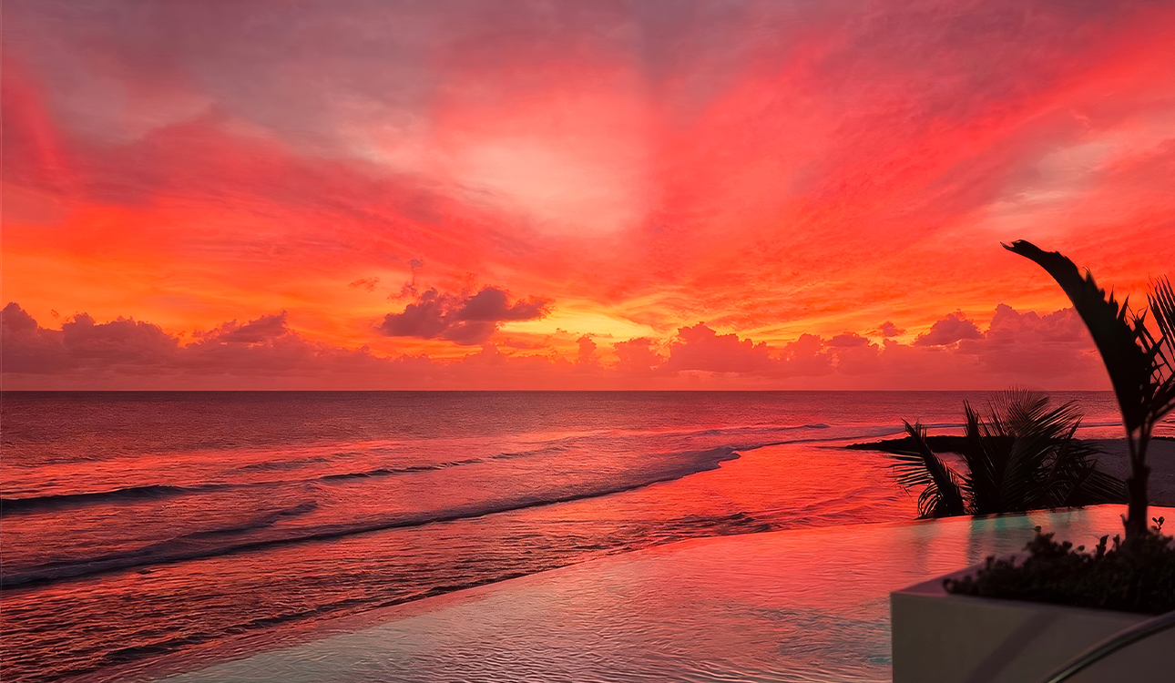 a pool with a sunset in the background