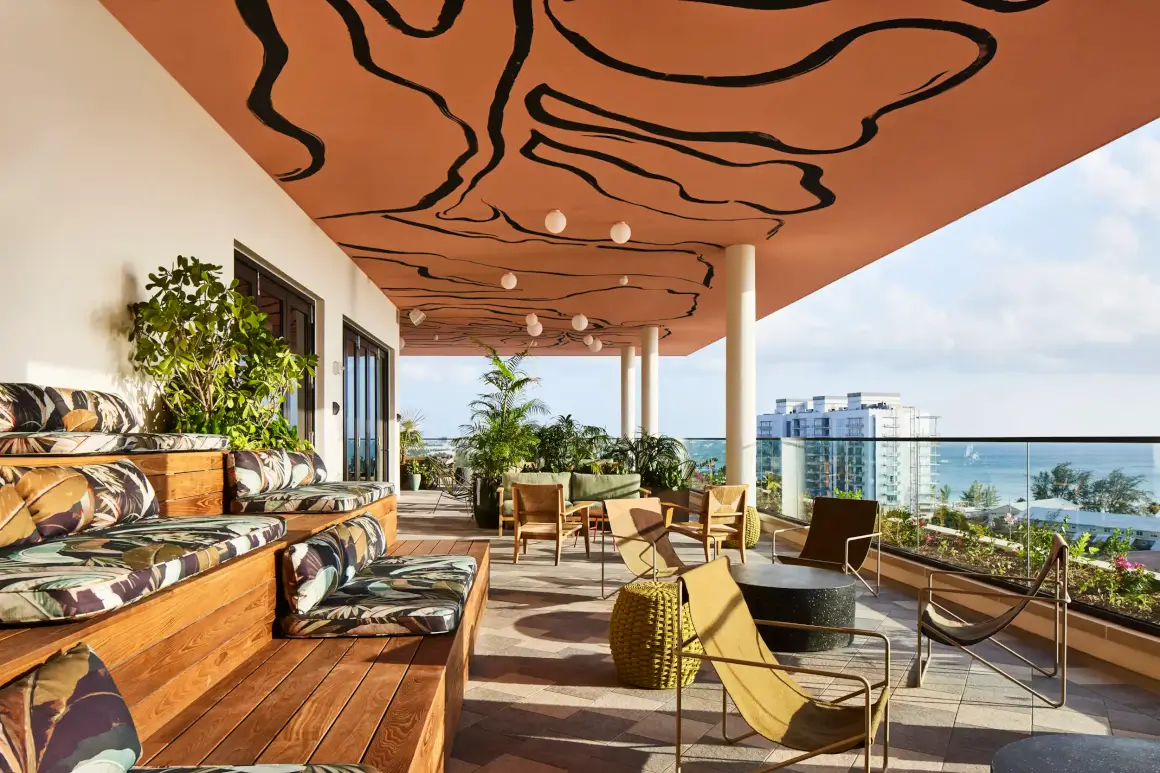 a patio with chairs and tables and a large wall