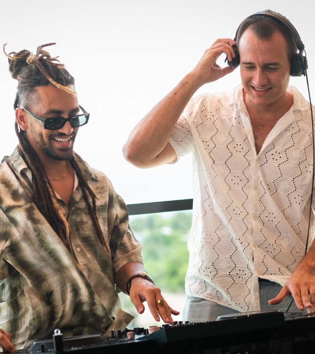 two men wearing headphones and smiling