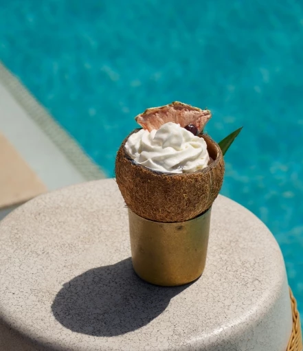 a coconut with whipped cream in a cup