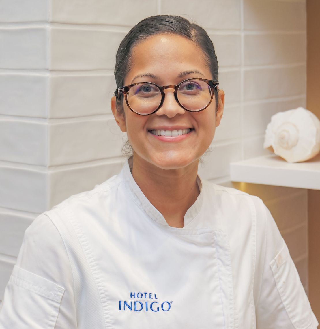 a woman wearing glasses and a white coat