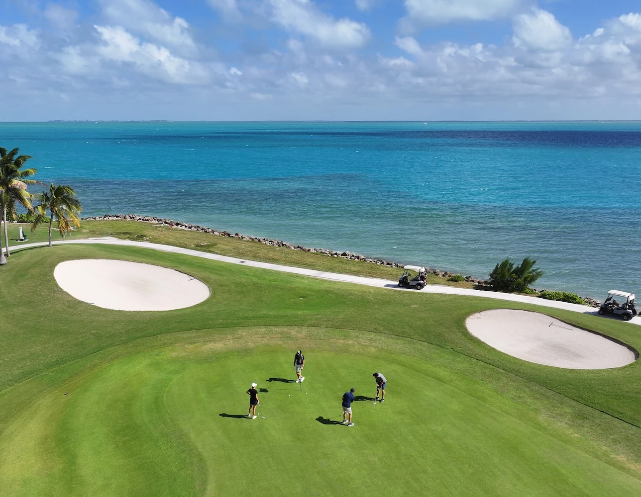 a group of people playing golf on a golf course