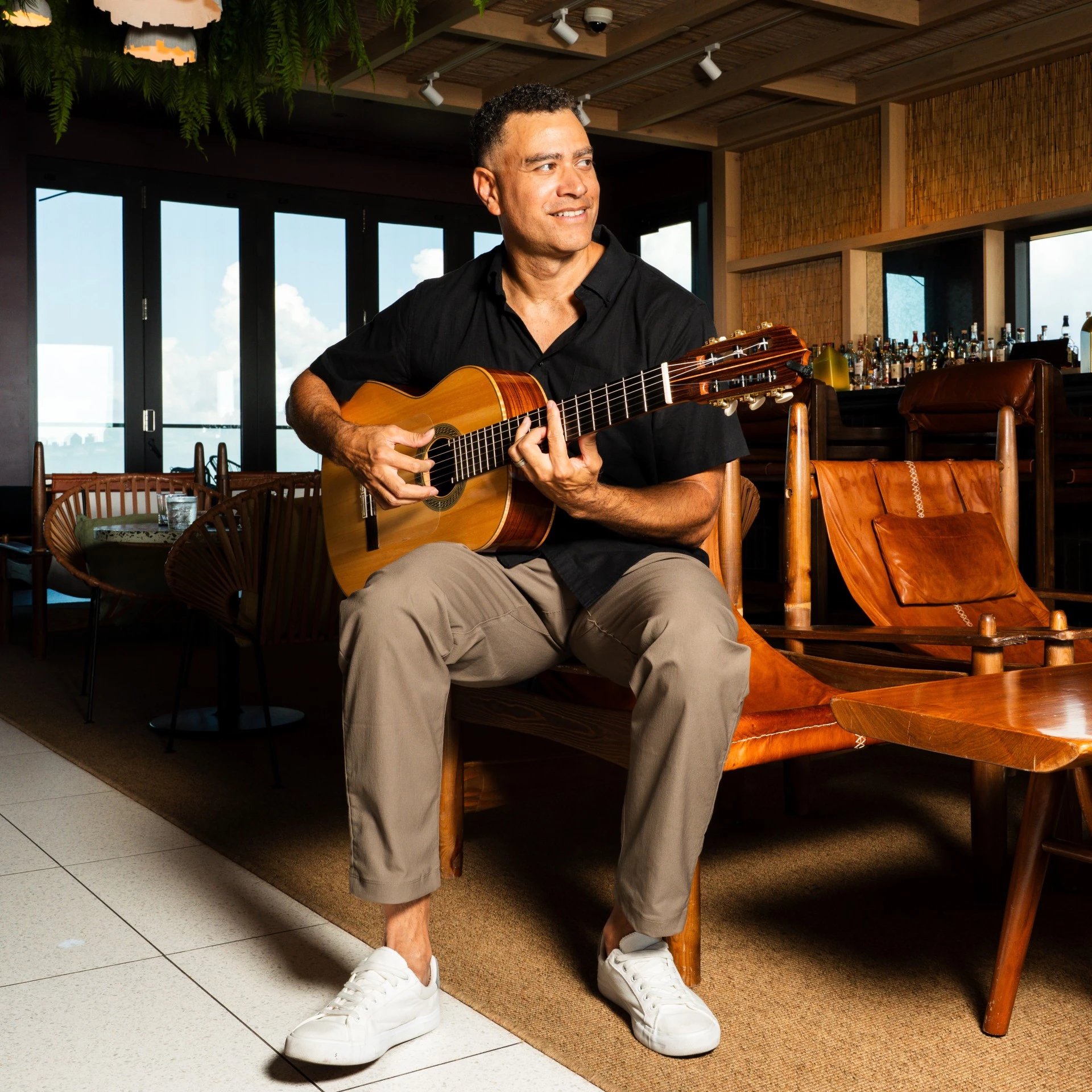 a man sitting in a chair playing a guitar