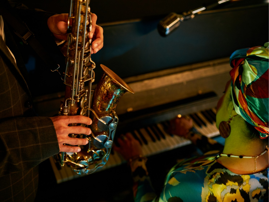a man playing a saxophone next to a woman playing a piano
