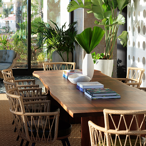a table with books and chairs in a room with a large window