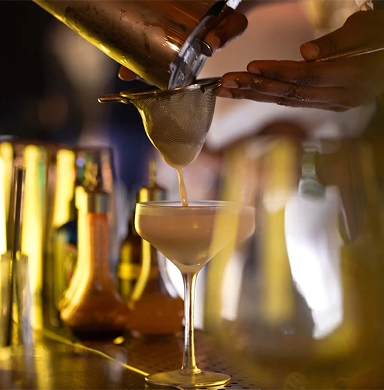 a person pouring liquid into a glass