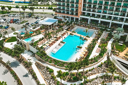 a swimming pool surrounded by palm trees and buildings