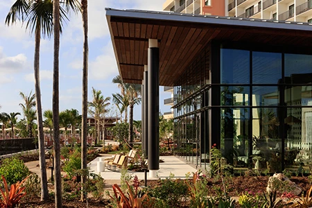 a building with a glass wall and a garden