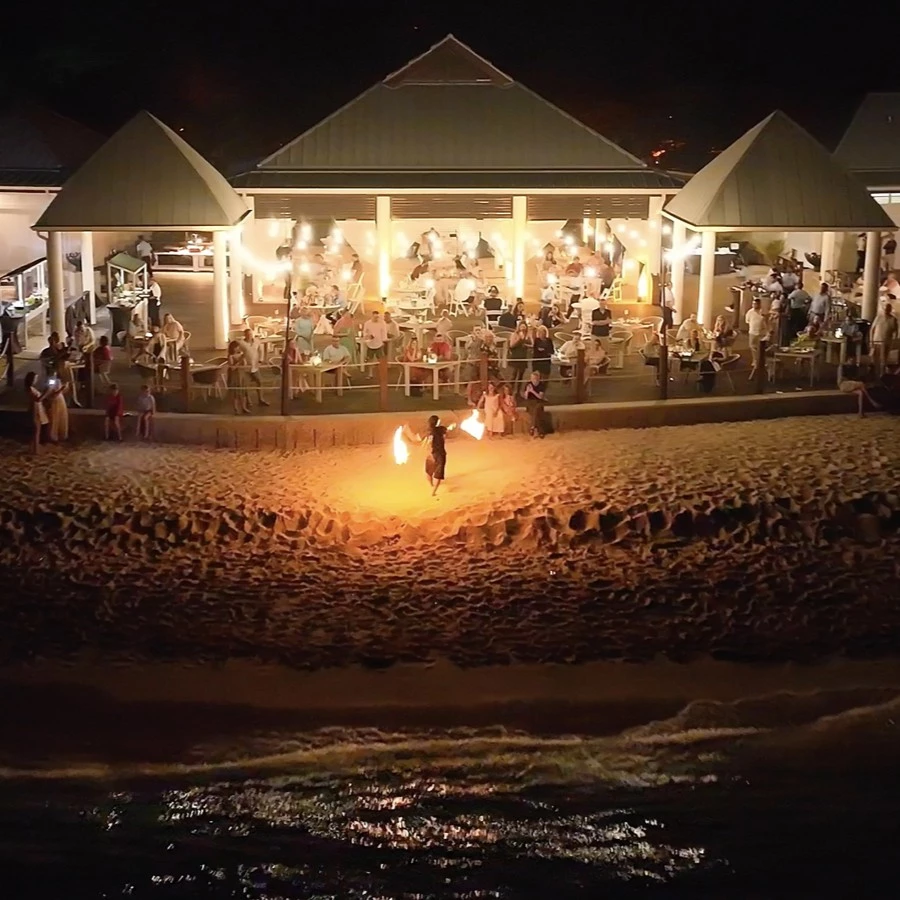 a person with fire in the air on a beach at night