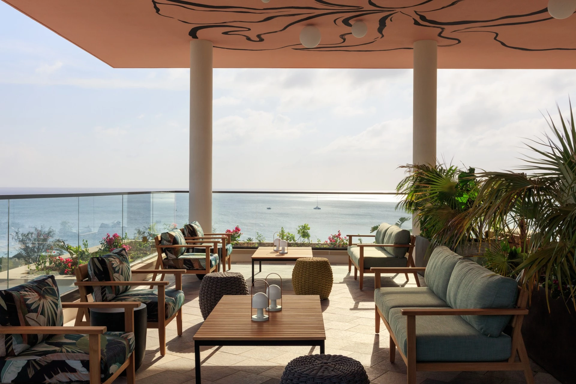 a patio with chairs and tables overlooking the ocean