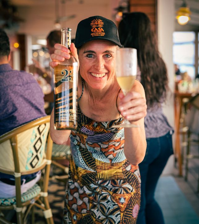 a woman holding a glass and a bottle