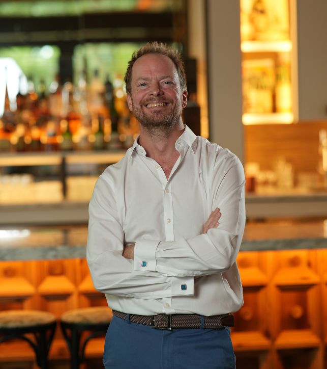 a man standing in front of a bar