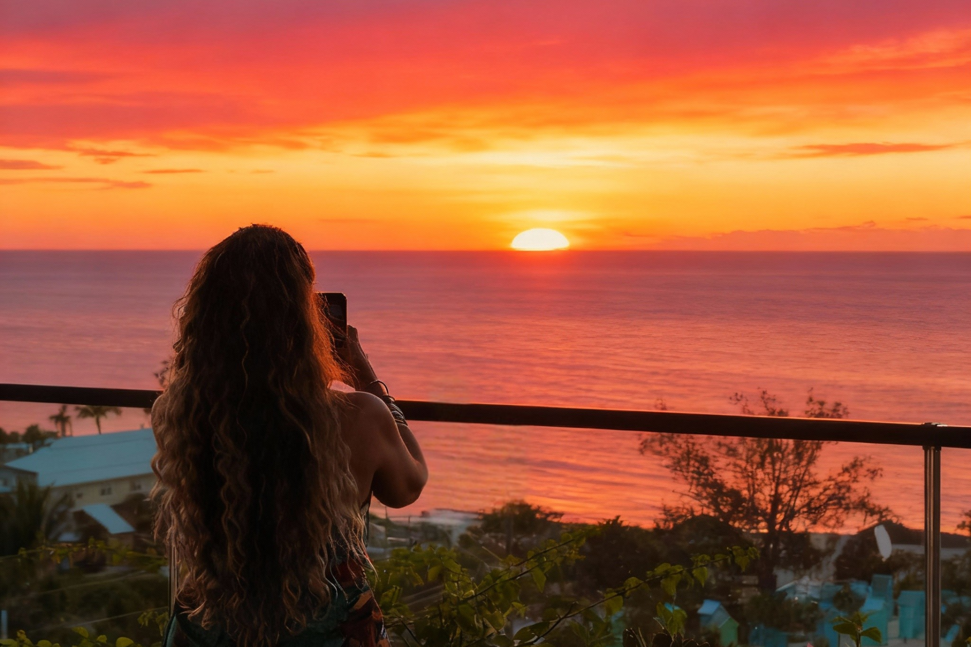 a woman taking a picture of the sunset