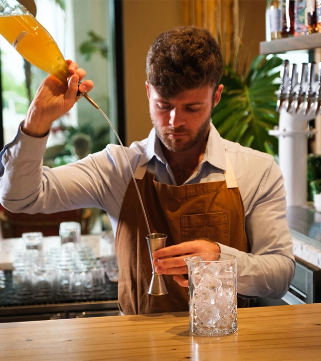 a man pouring a drink into a glass