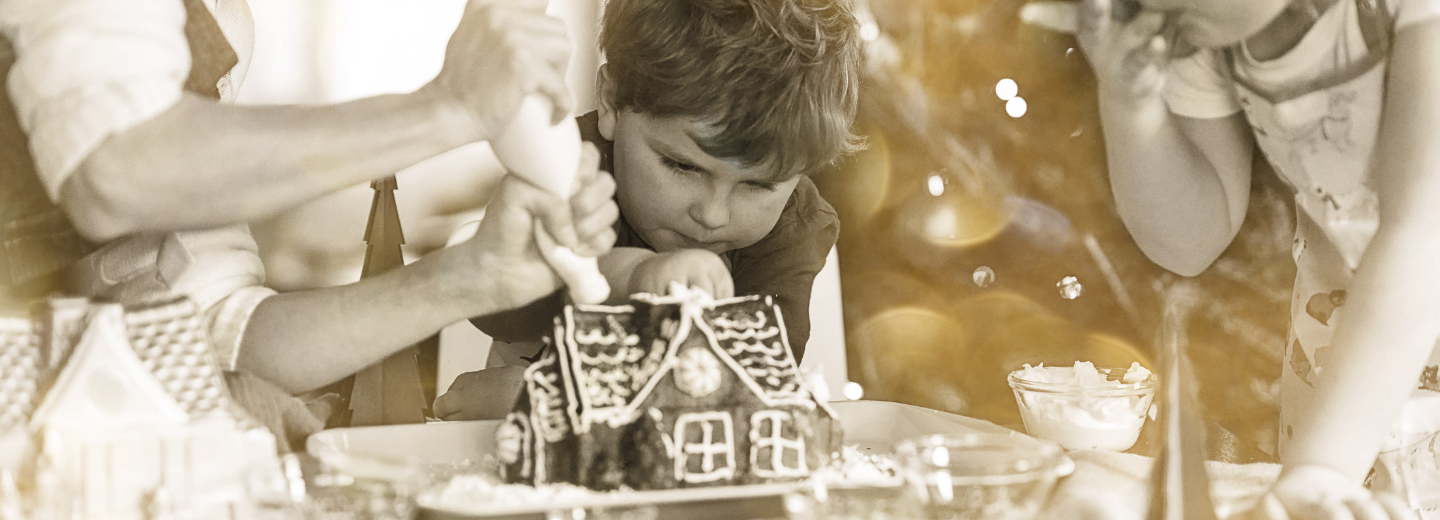 a child decorating a gingerbread house