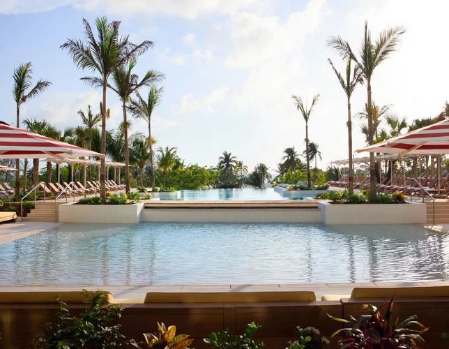 a pool with lounge chairs and palm trees