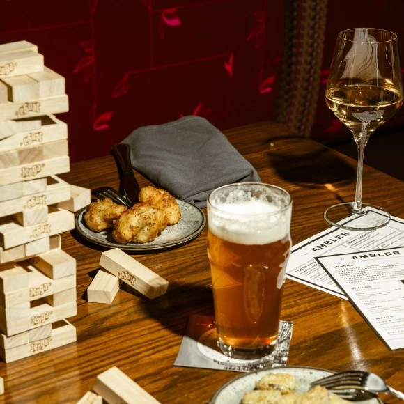 a table with a glass of beer and food on it