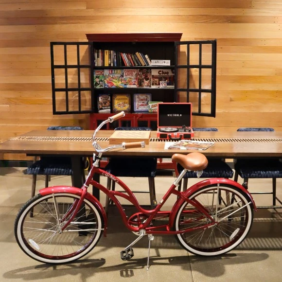 a red bicycle in front of a table