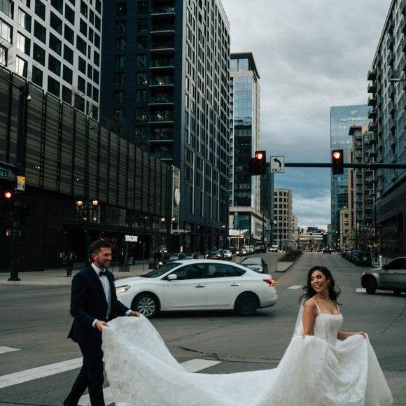 a man and woman in a wedding dress walking down a street