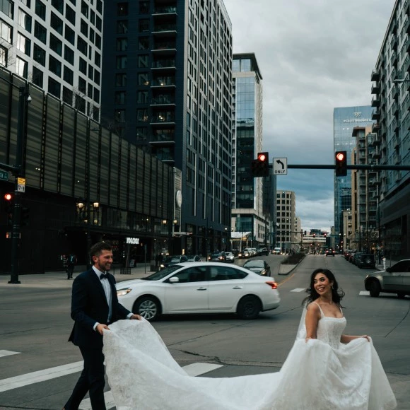 a man and woman in a wedding dress walking down a street