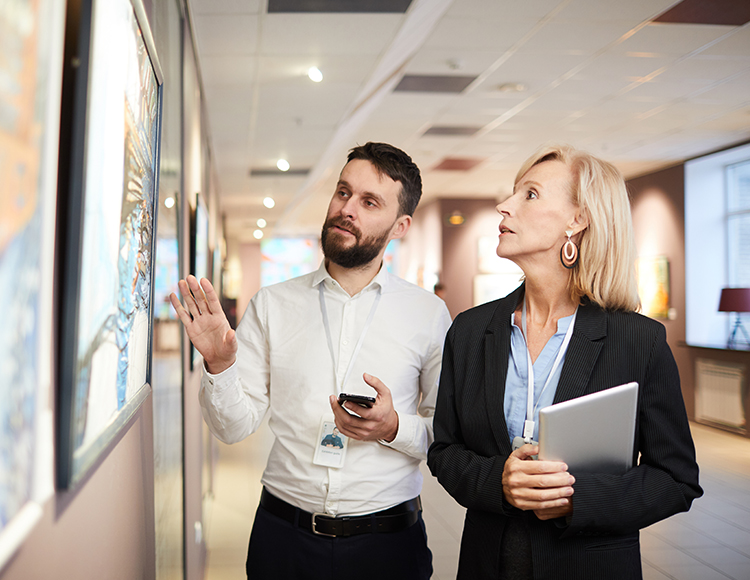 a man and woman looking at a piece of art