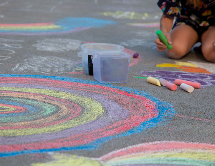 a child drawing with chalk on the ground